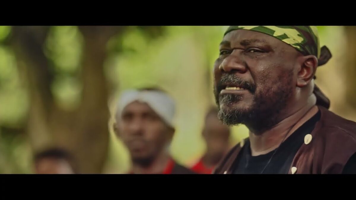 Sam Dede wearing a camouflage headband outdoors in Issakaba Returns