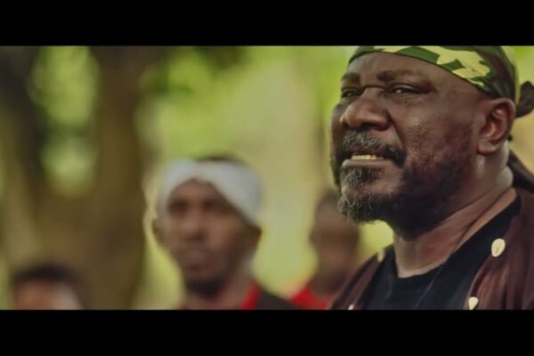 Sam Dede wearing a camouflage headband outdoors in Issakaba Returns